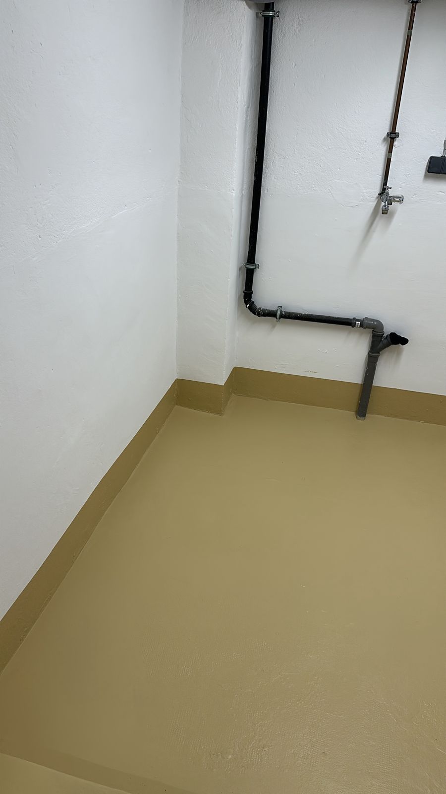 Raumecke mit an der Wand hochgezogenem Beschichtungssockel