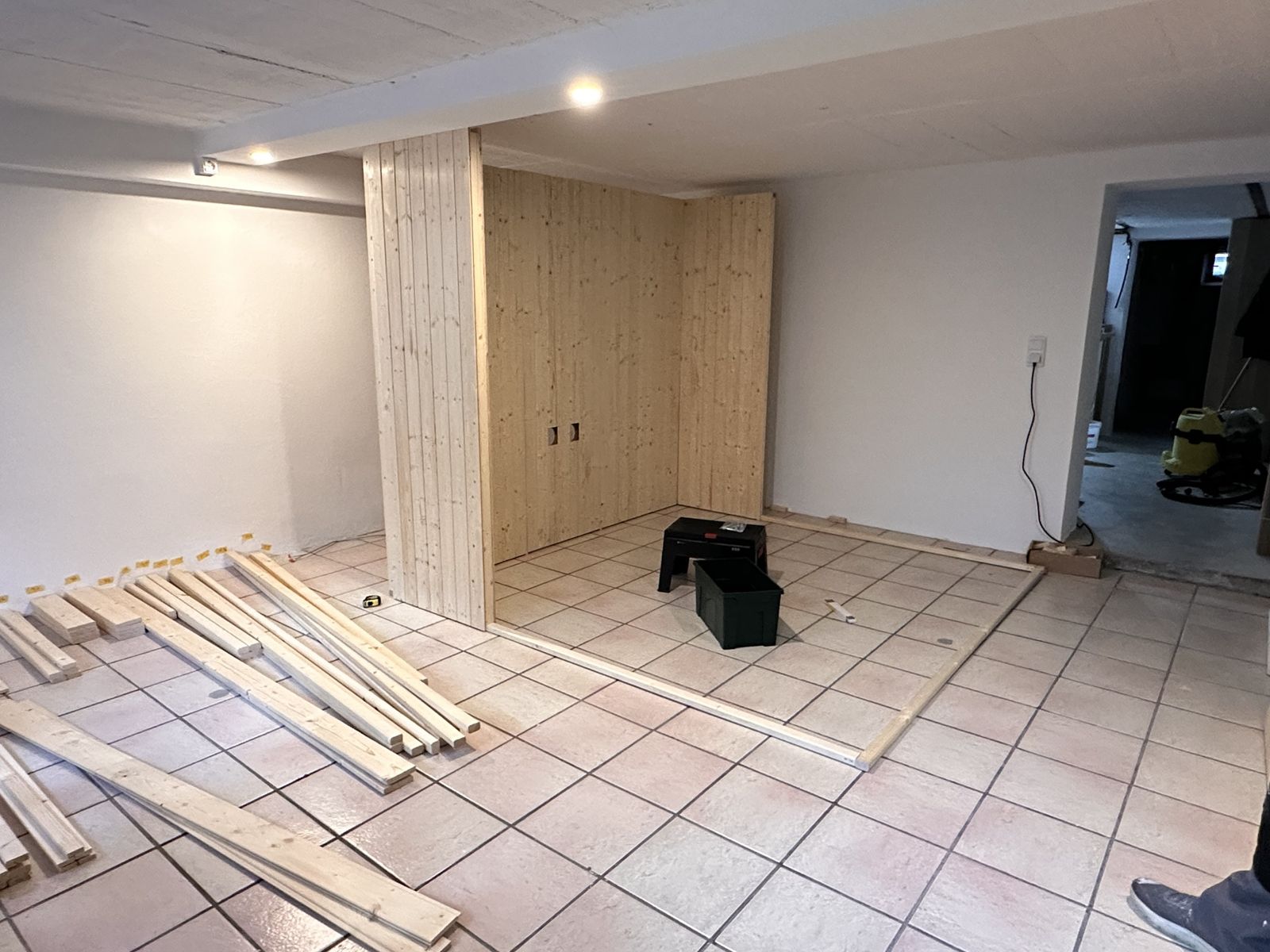 Wandelemente aus Fichtenholz werden im Kellerraum aufgestellt